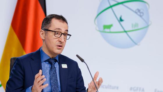 Bundeslandwirtschaftsminister Cem Özdemir hält Eröffnungsrede bei der Berliner Agrarministerkonferenz 2022. Im Hintergrund: eine Deutschlandflagge und ein GFFA-Logo.