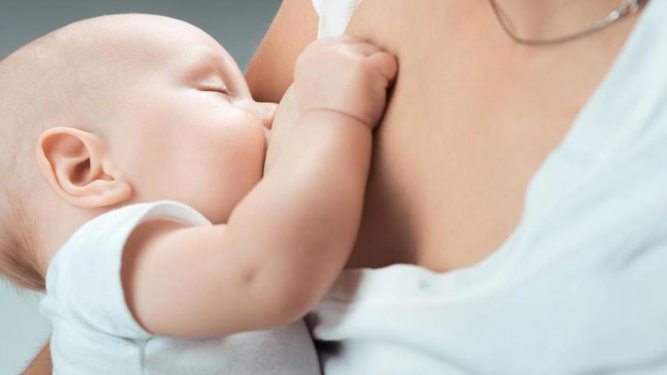 Baby beim Stillen an der mütterlichen Brust