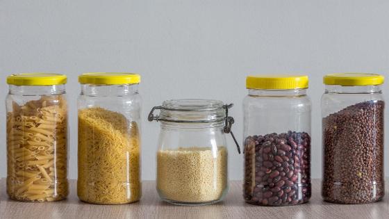 Glasbehälter mit trockenen Lebensmitteln wie Bohnen, Linsen, Nudeln