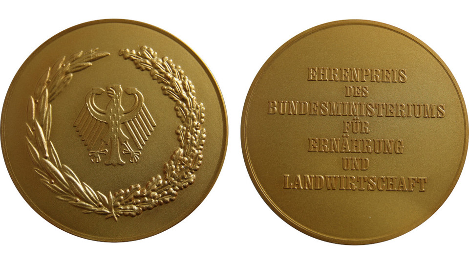 Foto der Vorder- und Rückseite des Bundesehrenpreises in Gold
