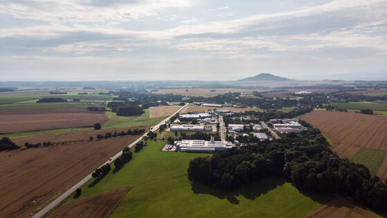 Luftaufnahme eines Industriegebietes im ländlichen Raum an einer Landstraße umgeben von Feldern