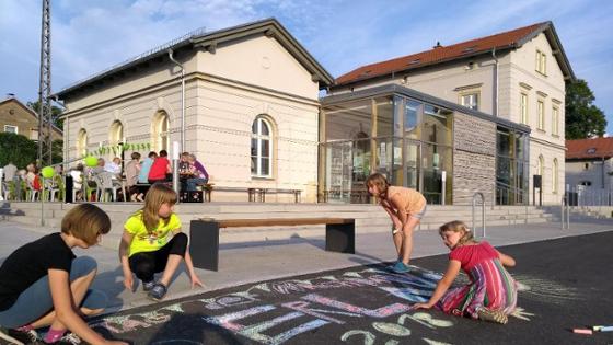 Kinder malen mit Kreide vor dem Generationenbahnhof Erlau